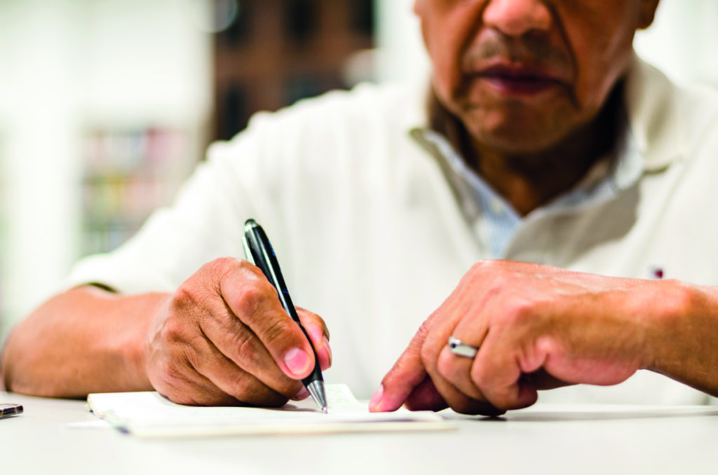 Un homme senior rédige son testament de façon sérieuse afin que ses dernières volontés soient respectées.